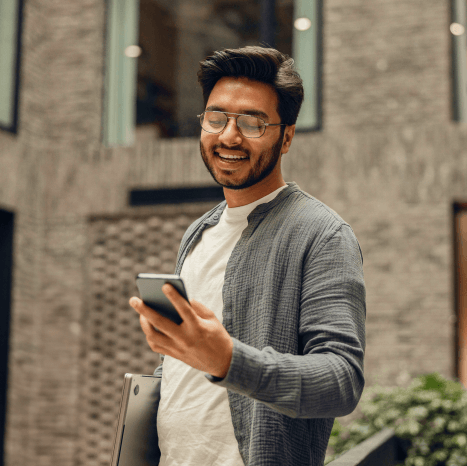 Man checking property listings on his phone, possibly searching for a new home or apartment.