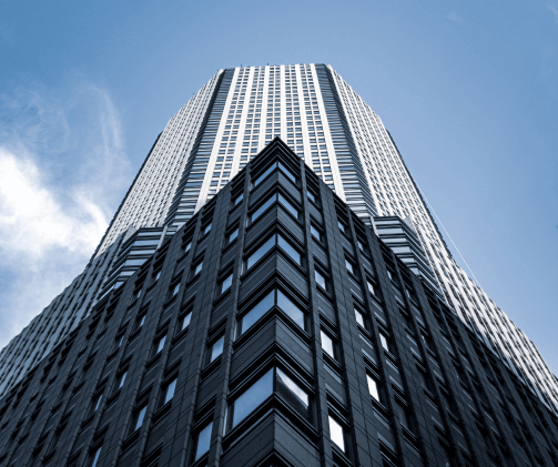 Skyscraper with a unique architectural design, showcasing a blend of dark stone and reflective glass surfaces.